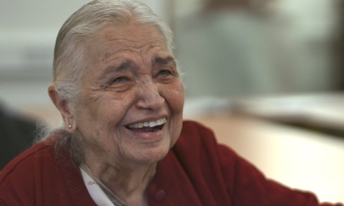 An older lady laughs to camera